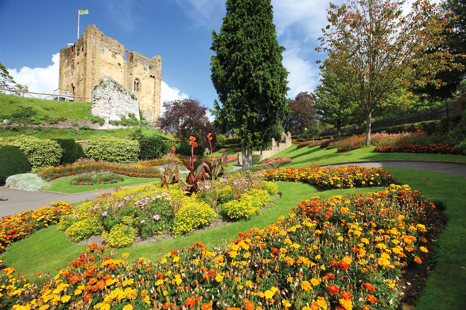 A garden filled with flowers and a castle 